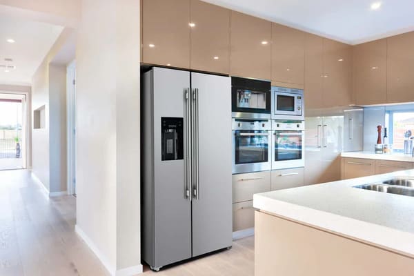 Lifestyle view of the FORNO 36-inch refrigerator with water dispenser in stainless steel, integrated into a modern kitchen environment with surrounding cabinetry and decor.