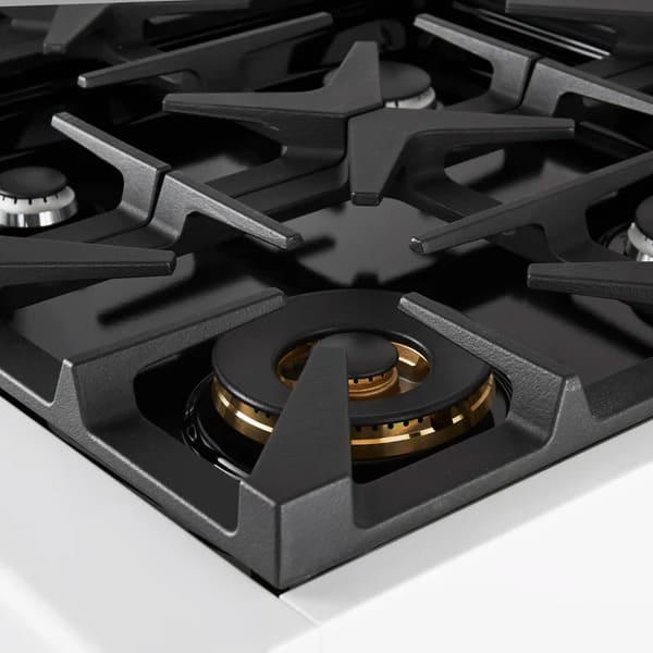 Close-up of a brass burner on the FORNO Antico 36-Inch Gas Range in white, featuring precision flame ports, heavy-duty cast iron grates, and a sleek white surface for a premium look.