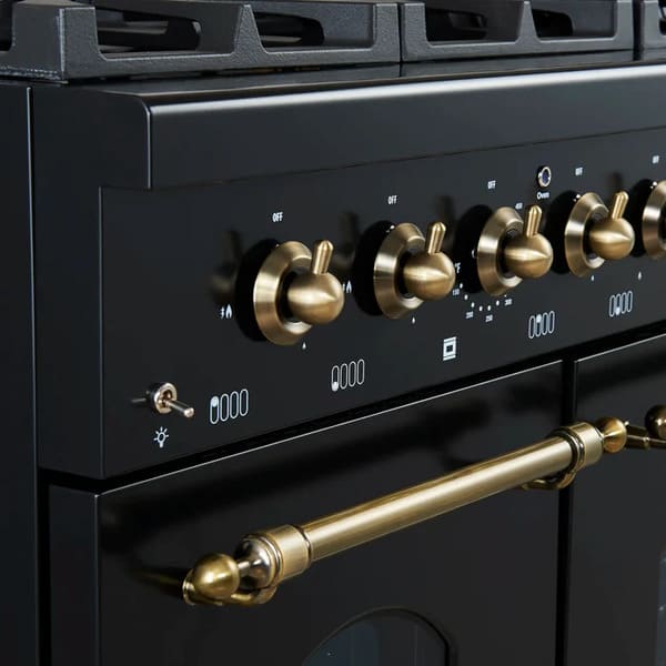 Close-up view of the control knobs on the Forno Antico 48-Inch Gas Range, featuring polished brass bezels, stainless steel knobs, and precision temperature markings for professional cooking control.